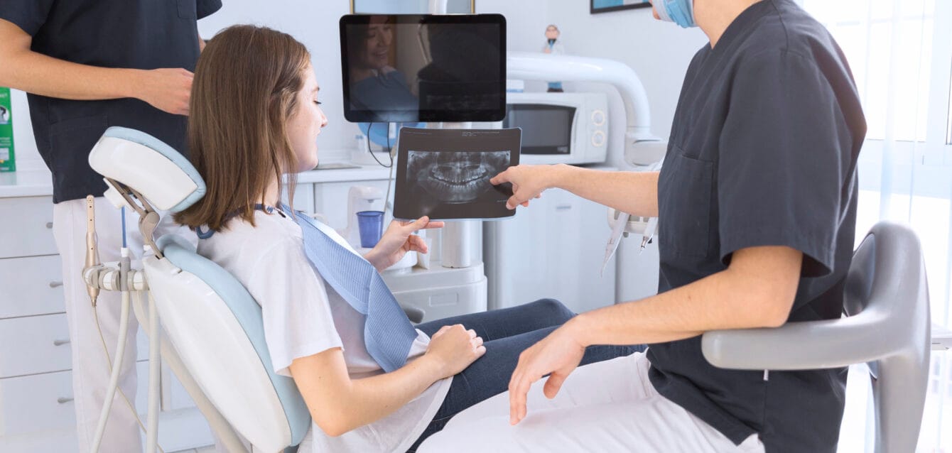 happy-smiling-dentist-showing-dental-x-ray-female-patient happy-smiling-dentist-showing-dental-x-ray-female-patient